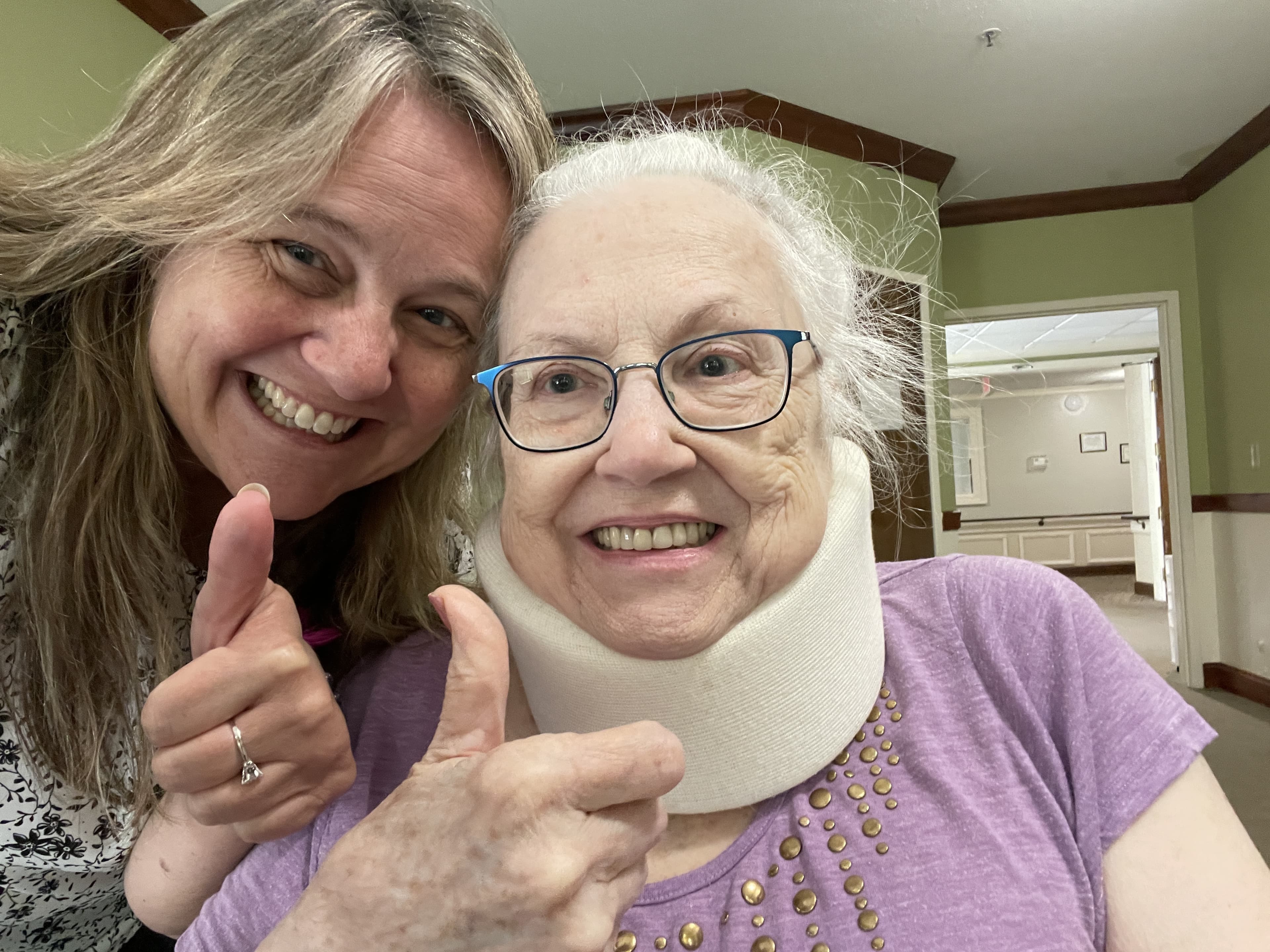 Hazel with neck brace giving a thumbs up, with Starr