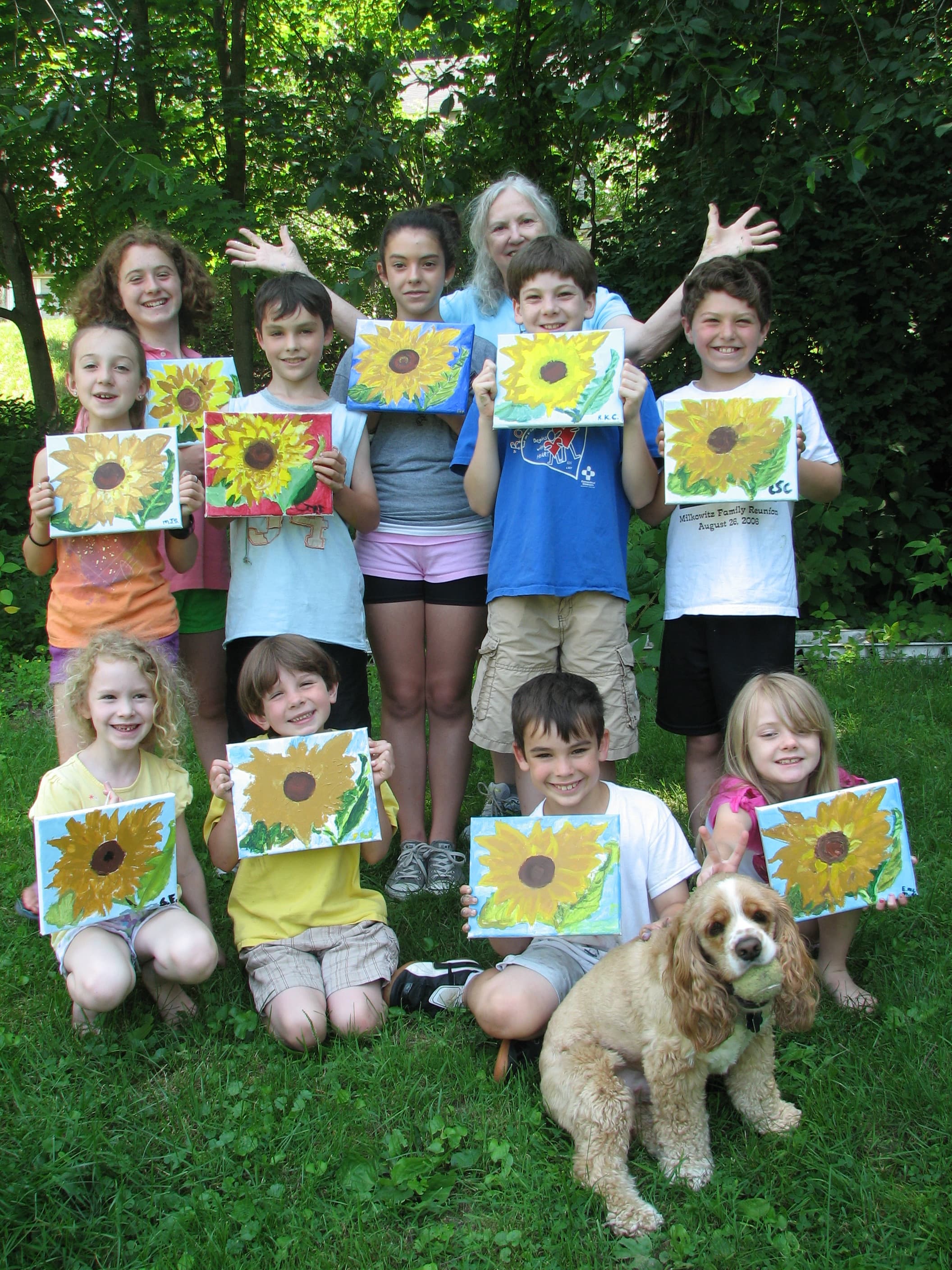 Hazel with children holding sunflower paintings
