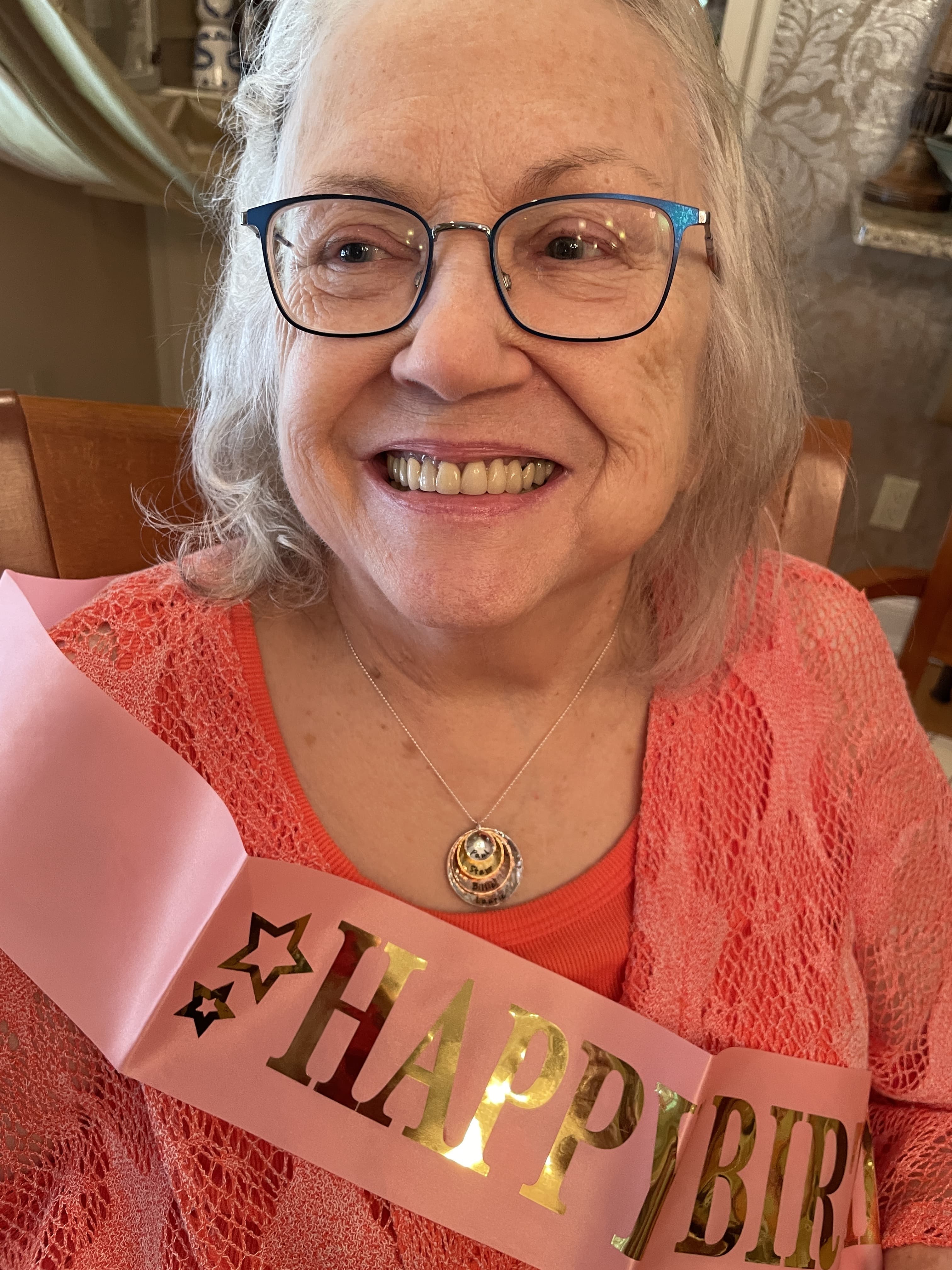 Hazel wearing a Happy Birthday sash, smiling